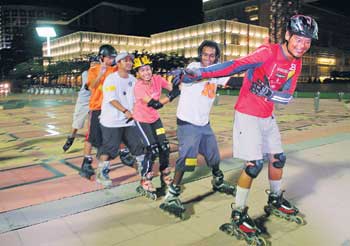 FOLLOW ME: Khoo leading the boys on a tandem skate. - Pictures by Munira Abdul Ghani.